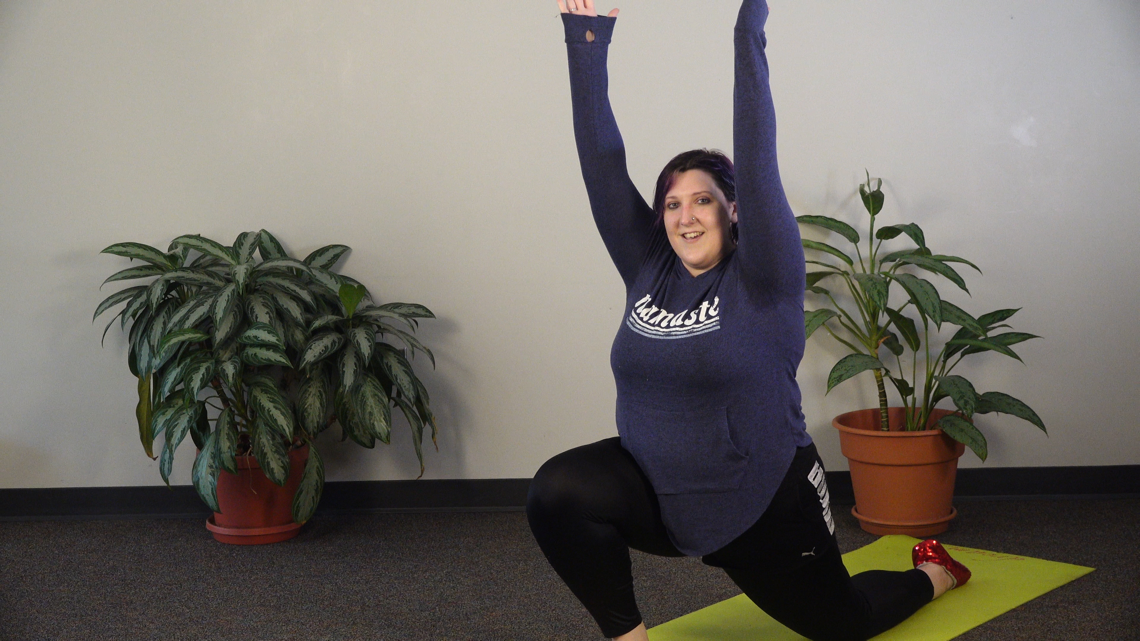 This picture features Ms. Hannah in a dinosaur/dragon yoga pose. 
