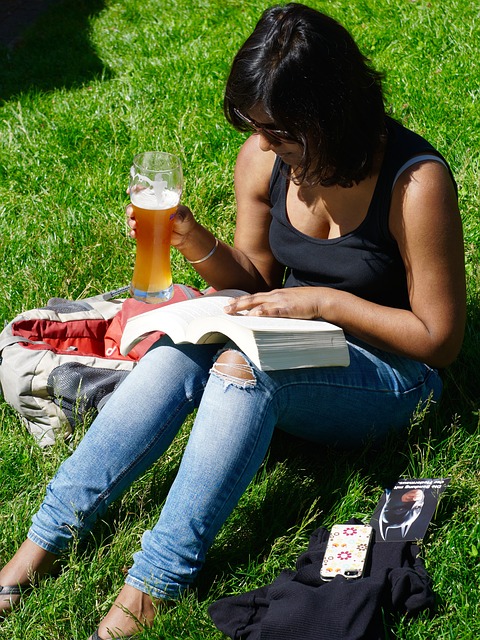 woman reading outside with a beer