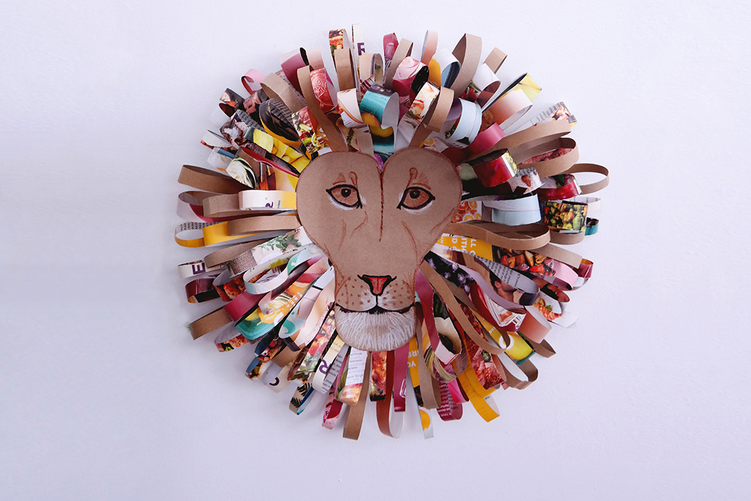 a lion wall hanging made of paper grocery bags and strips cut from magazines